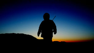 An Inuit hunter looks out on the Arctic horizon at sunrise in Frobisher Bay near Tonglait, Nunavut, in February 2003. Inuit and other High Arctic residents say their winters are getting lighter as the climate warms.