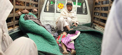 Local residents display the body of a child they say was killed during a rampage by US Army Sergeant Robert Bales. (photo: Allauddin Khan/AP)