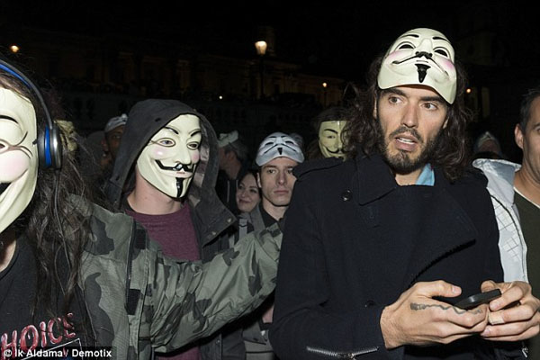 A masked Russell Brand leads Anonymous march against austerity cuts Funnyman-turned-activist joins protesters as they aim fireworks at Buckingham Palace